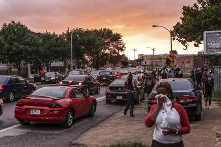 Neighborhood residents cover their faces as the St. Louis Police Department used tear gas to disperse the growing crowd due to a police shooting earlier in the day in St. Louis, Missouri August 19, 2015. REUTERS/Lawrence Bryant