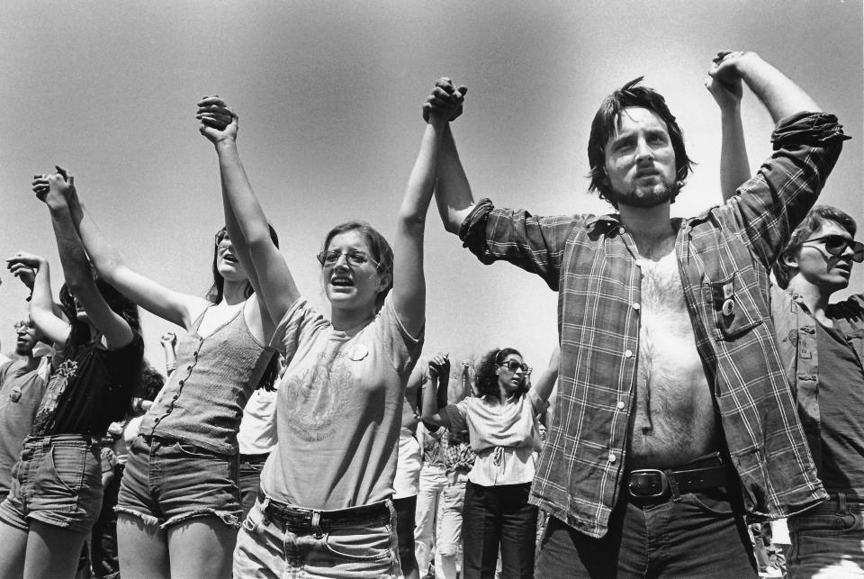 Attendees at a rally to commemorate the 1970 shootings at Kent State hold hands during the 10th anniversary memorial ceremonies at the university, May 4, 1980.