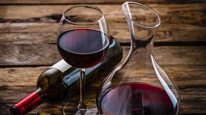 Red wine in glass and decanter next to a bottle