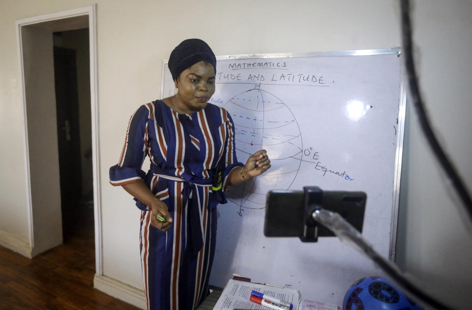 Mathematics teacher Basirat Olamide Ajayi, 36, teaches longitude and latitude online via her mobile phone from her house in Lagos, Nigeria Saturday, Aug. 15, 2020. The teacher from a Lagos public school is helping students across the country, and internationally, learn math virtually during coronavirus restrictions that have prevented most children from returning to class in Nigeria. (AP Photo/Sunday Alamba)