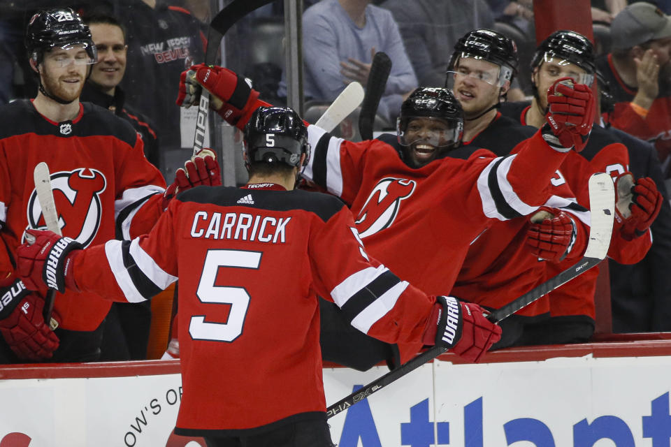 New Jersey Devils defenseman Connor Carrick (5) celebrates with defenseman P.K. Subban, center right, during the second period of an NHL hockey game against the St. Louis Blues, Friday, March 6, 2020, in Newark. (AP Photo/John Minchillo)