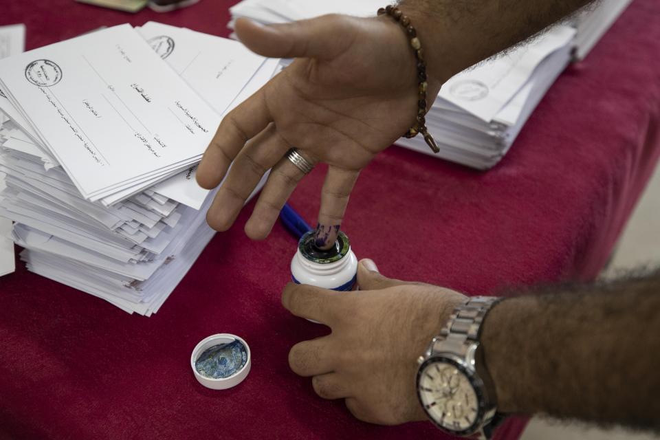 A Syrian man inks his finger after hw votes at a polling station during the Presidential elections in the Syrian capital Damascus, Syria, Wednesday, May 26, 2021. Syrians headed to polling stations early Wednesday to vote in the second presidential elections since the deadly conflict began in the Arab country. (AP Photo/Hassan Ammar)