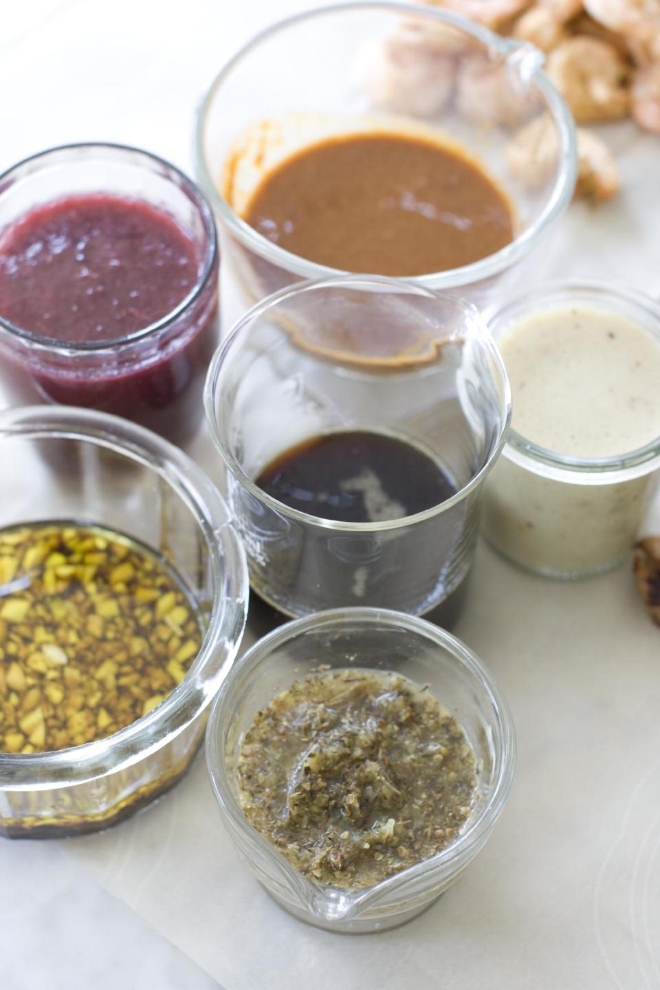 This July 29, 2013 photo shows, clockwise from top, marinades of orange ginger, white wine mustard, lemon herb and garlic balsamic in Concord, N.H. At center is maple soy. (AP Photo/Matthew Mead)