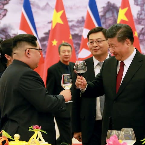 President Xi Jinping (R) and North Korean leader Kim Jong Un (L) raising their glasses at the Great Hall of the People in Beijing - Credit: KCNA/AFP