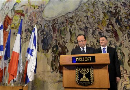 Yuli Edelstein (R), Speaker of the Knesset, Israel's parliament, stands behind France's President Francois Hollande as he signs the guest book at the parliament in Jerusalem November 18, 2013. Hollande called on Israel on Monday to halt settlement building on occupied territory, saying it hampers chances for a peace agreement with the Palestinians. REUTERS/Debbie Hill/Pool