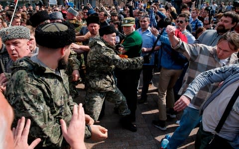 A Cossack whips opposition protesters in Moscow in May - Credit: Maxim Zmeyev/AFP