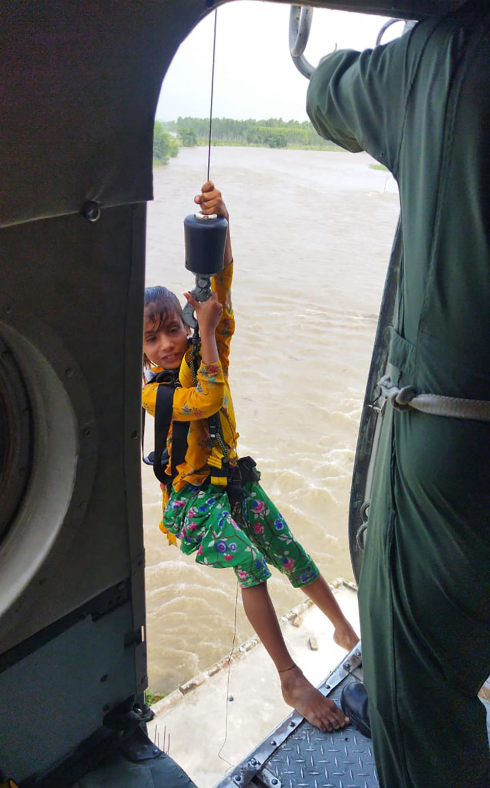 In this photo provided by the Indian air force, a child is airlifted from a flood-affected area in Himachal Pradesh state, India, August 2023. Days of relentless rain in India’s Himalayan region have killed more than 70 people this week, a government official said Thursday, as a heavy monsoon triggered landslides and flash floods that have submerged roads, washed away buildings and left residents scrambling for safety.(Indian Air Force via AP)