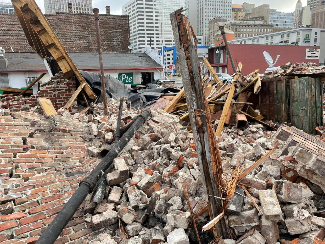 Pile of bricks, metal pipe, and wood from a building collapse.