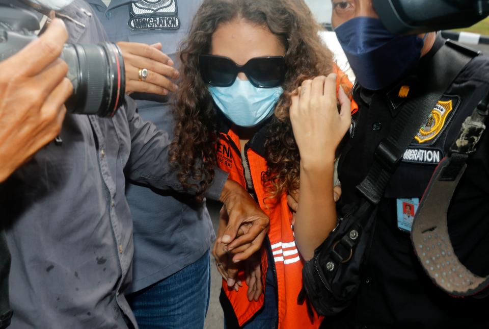 Mack escorted by Indonesian immigration workers in November 2021 after her release from Bali prison (Copyright 2021 The Associated Press. All rights reserved.)