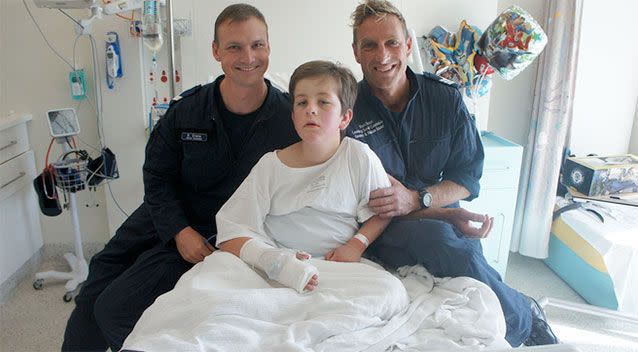 Luke Shambrook pictured from his hospital bed with two of his hero rescuers. Photo: Supplied