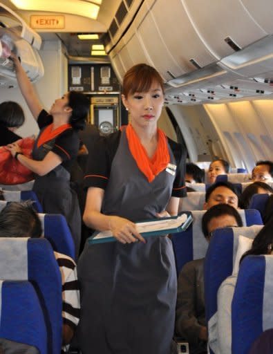 Transsexual fight attendant Chayathisa Nakmai (right) works onboard a Thai PC Air flight between Bangkok and Hong Kong on March 9. Fledgling Thailand-based carrier PC Air has hired four transgender cabin crew in a highly publicised recruitment drive that has divided opinion over whether the move is in the spirit of equality or exploitation