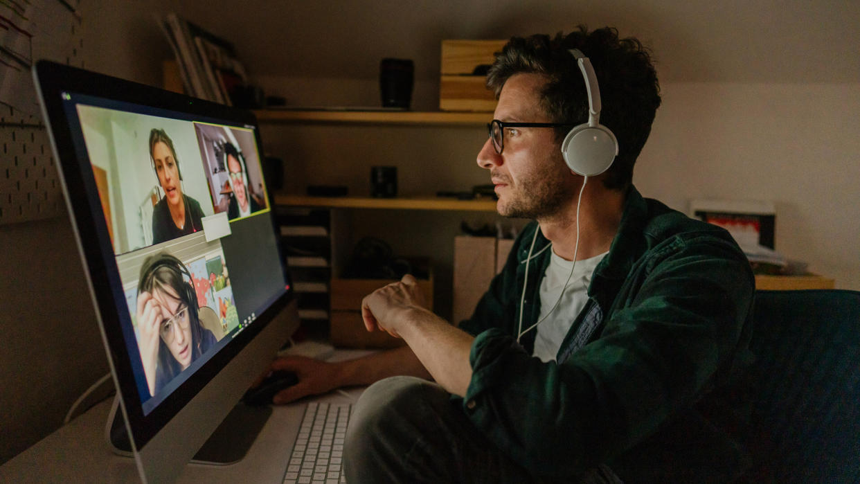 Photo of a man having a video conference call with his colleagues.