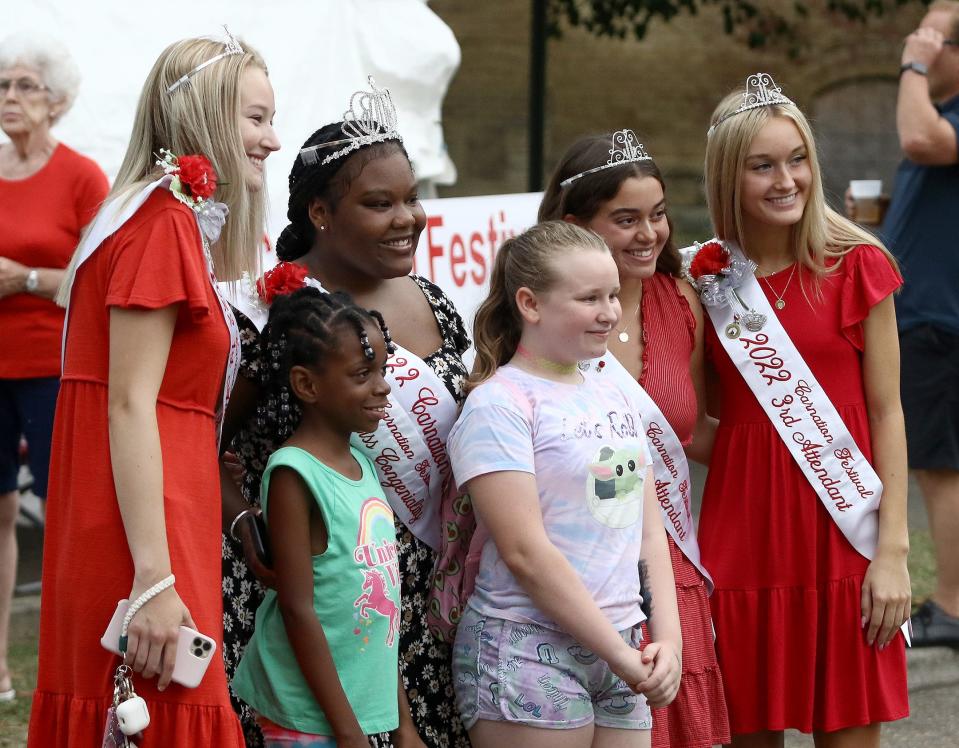 2022 Carnation Festival queen Kayla Martin, back row, second from left, and her court members pose for a photo with Alana Board, front at left, and Alaynah Sherrill, front at right, on Thursday, Aug. 4, 2022, during the Greater Alliance Carnation Festival Food Fest on East Main Street.
