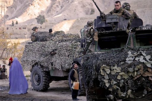 A file photo, taken in 2008, shows an Afghan woman (L) holding her child as a boy looks up at French soldiers as they patrol in the village of Surobi, some 60km east of Kabul. The French president's office on Saturday confirmed that four French soldiers were killed and five were wounded in an attack claimed by the Taliban in Afghanistan's eastern Kapisa province