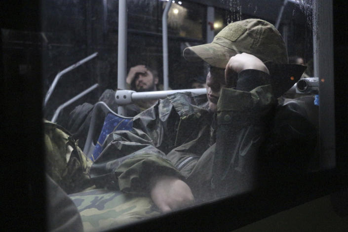 Ukrainian servicemen sit in a bus after leaving Mariupol's besieged Azovstal steel plant, near a penal colony, in Olyonivka, in territory under the government of the Donetsk People's Republic, eastern Ukraine, Friday, May 20, 2022. (AP Photo)