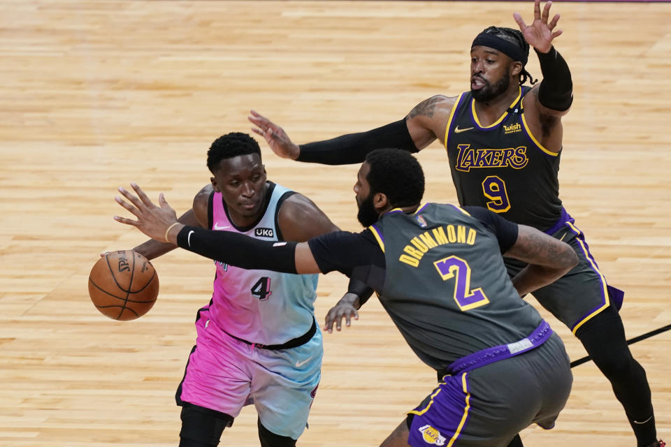 Los Angeles Lakers guard Wesley Matthews (9) and center Andre Drummond (2) defend Miami Heat guard Victor Oladipo (4), during the second half of an NBA basketball game, Thursday, April 8, 2021, in Miami. (AP Photo/Marta Lavandier)