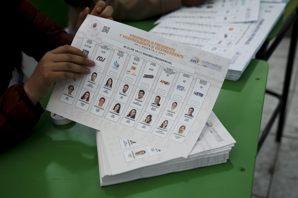 An electoral official shows the ballot for a snap presidential election in Ayora, Ecuador, Sunday, Aug. 20, 2023. The election was called after President Guillermo Lasso dissolved the National Assembly by decree in May to avoid being impeached. (AP Photo/Dolores Ochoa)