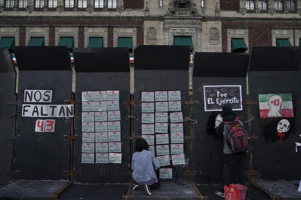 Demonstrators post signs of the missing 43 Ayotzinapa college students on a security barricade ringing the National Palace, during a march in Mexico City, Monday, Sept. 26, 2022, on the day of the anniversary of the disappearance of the students in Iguala, Guerrero state. Three members of the military and a former federal attorney general were recently arrested in the case, and few now believe the government's initial claim that a local drug gang and allied local officials were wholly to blame for seizing and killing the students on July 26, 2014, most of which have never been found. (AP Photo/Eduardo Verdugo)