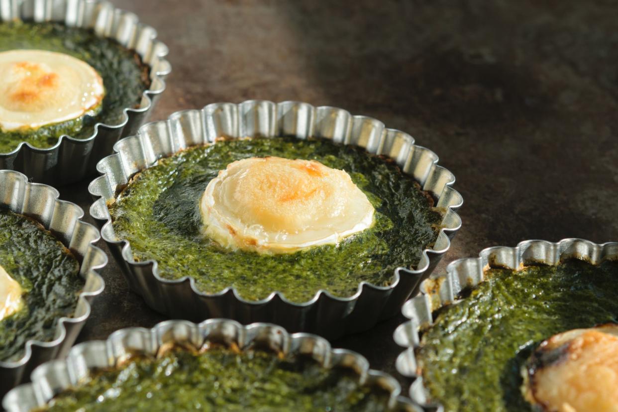 spinach cakes in metallic tart holds