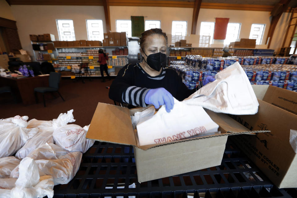 Rev. Roslyn Bouier, Director of the Brightmoor Connection Food Pantry prepares bags of food in Detroit, Monday, March 23, 2020. The global coronavirus pandemic has brought water shutoffs in Detroit and in communities across the nation into sharp focus again amid a crucial time when officials are urging Americans to practice social distancing and basic hand-washing techniques to stop the spread of COVID-19.(AP Photo/Paul Sancya)