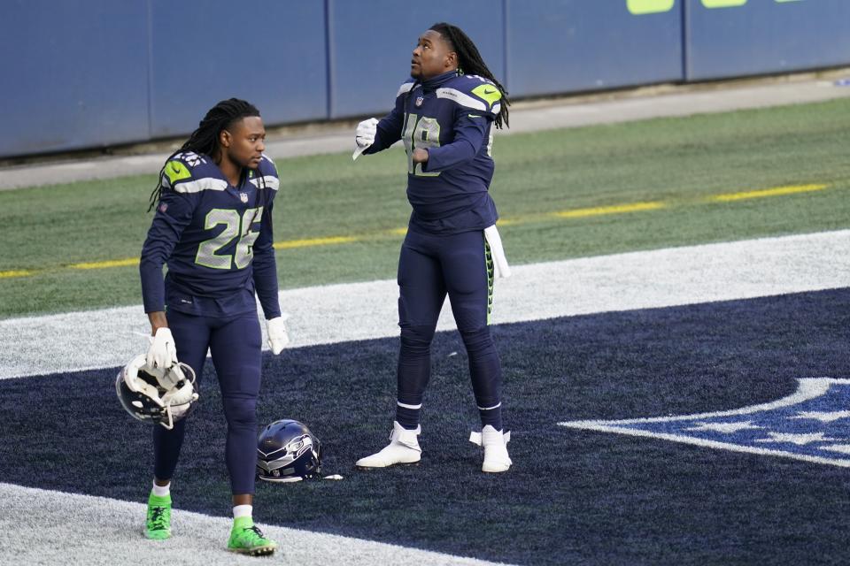 FILE - Twin brothers Seattle Seahawks cornerback Shaquill Griffin (26) and linebacker Shaquem Griffin (49) on the field before an NFL football game against the Los Angeles Rams, Sunday, Dec. 27, 2020, in Seattle. The Griffin twins are already talking trash three months before they’re on opposite sidelines for the first time in their lives. Shaquill and Shaquem Griffin were teammates at every level of football growing up in St. Petersburg. They also played together at UCF and with the Seattle Seahawks the last three years. The seemingly inseparable brothers hit free agency in March and hoped to be reunited again. But it didn’t work out. (AP Photo/Elaine Thompson, File)