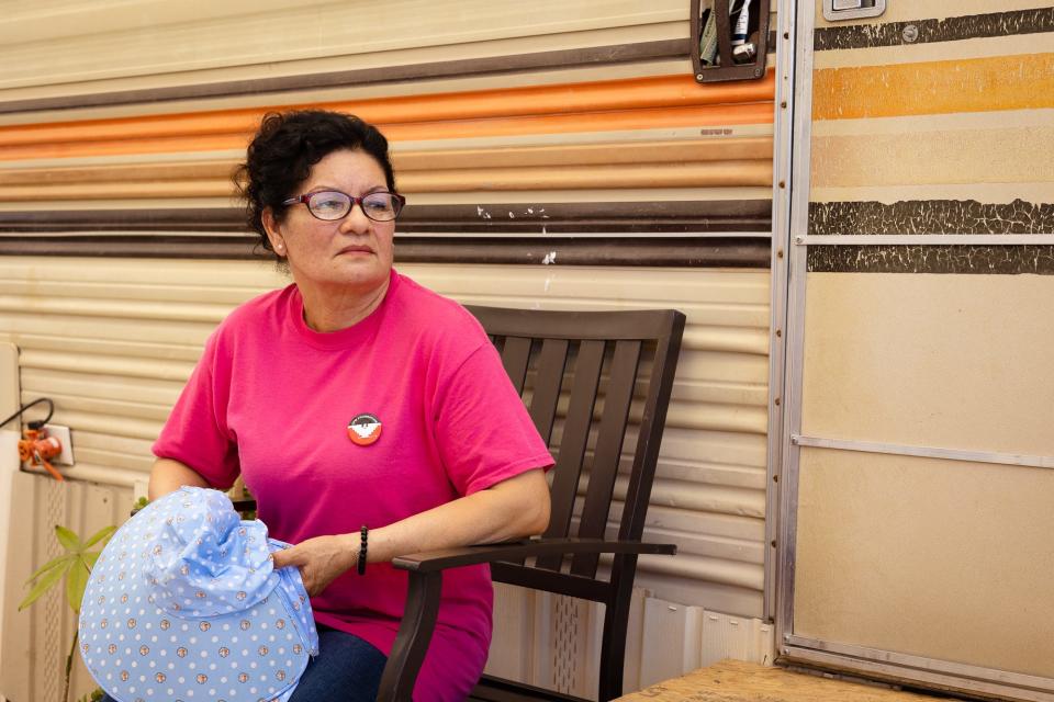 Maria Rosa Vega Murillo, a farmworker living in Somerton in Yuma County, sits outside her mobile home on May 21, 2023, holding the hat she uses for sun protection in the fields.