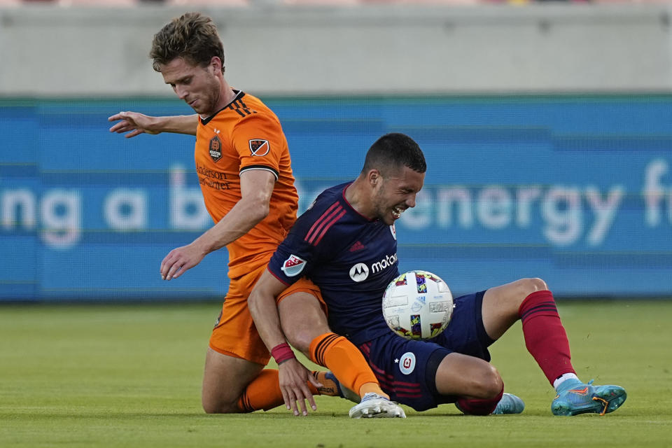 Houston Dynamo's Adam Lundqvist, left, tackles Chicago Fire's Stanislav Ivanov while during the first half of an MLS soccer game Saturday, June 25, 2022, in Houston. (AP Photo/David J. Phillip)