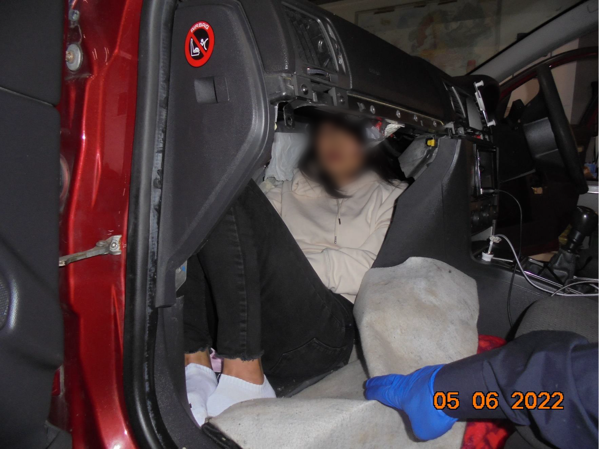 A people smuggler was caught attempting to bring this Vietnamese woman into the UK in this tiny space behind the car's dashboard (Crown Copyright)