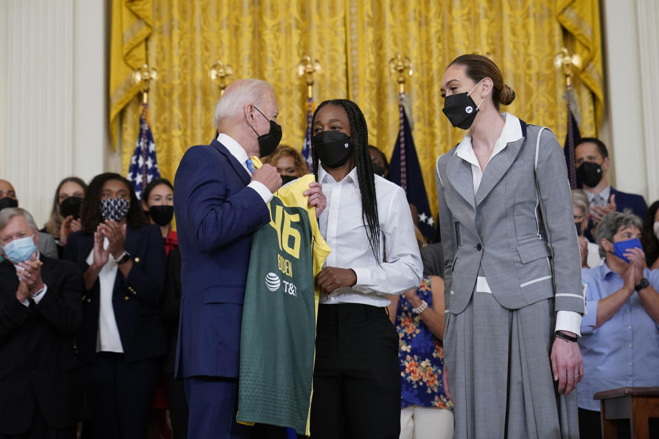 President Joe Biden, left, talks with Seattle Storm's Jewell Loyd, center, and Breanna Stewart, right, during an event in the East Room of the White House in Washington, Monday, Aug. 23, 2021, to celebrate their 2020 WNBA Championship. (AP Photo/Susan Walsh)