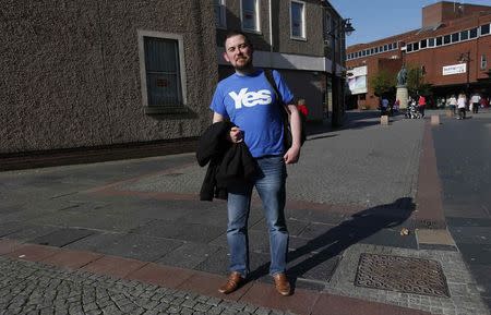 Neal Ingram, wearing a "Yes" t-shirt, poses near the Burns Mall in Kilmarnock, Scotland, April 29, 2014. REUTERS/Suzanne Plunkett