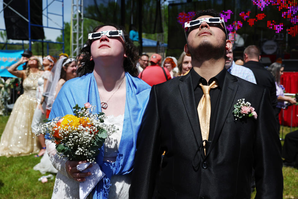 Couples view the solar eclipse during a mass wedding at the Total Eclipse of the Heart festival on April 8, 2024 in Russellville, Arkansas.  / Credit: Mario Tama/Getty Images