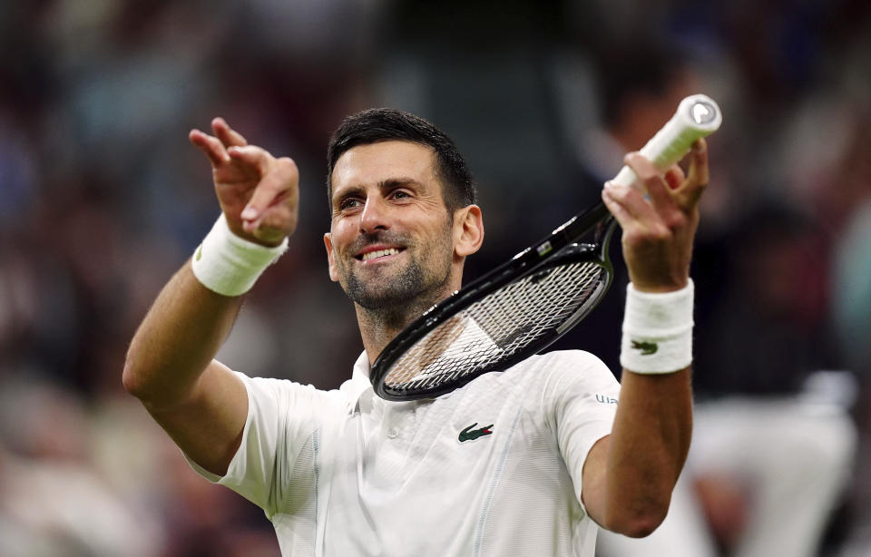 Novak Djokovic of Serbia pretends to play a violin after defeating Holger Rune of Denmark in their fourth round match at the Wimbledon tennis championships in London, Monday, July 8, 2024. (Mike Egerton/PA via AP)