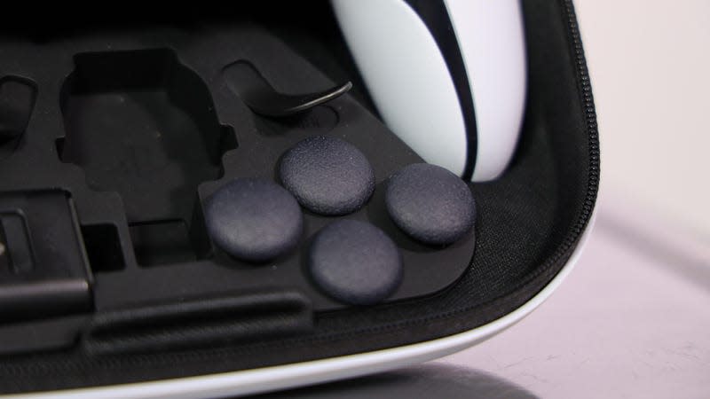 The DualSense Edge's replaceable analog sticks are seen sitting in the case alongside the controller itself.