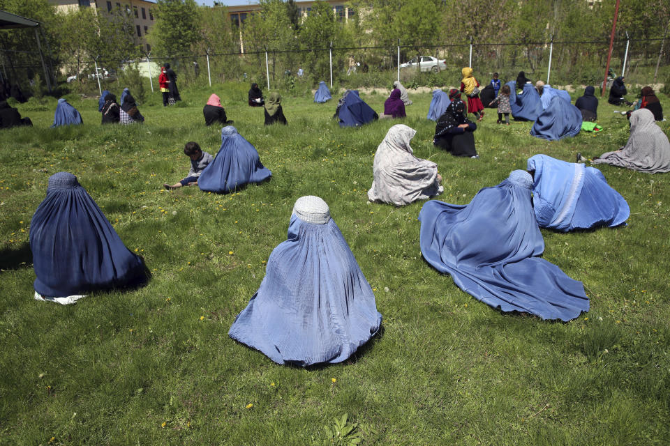 CORRECTS DATE TO TUESDAY, APRIL 21, 2020 -- Afghans wait to receive free wheat donated by the Afghan government ahead of the upcoming holy fasting month of Ramadan, during a quarantine for the coronavirus, in Kabul, Afghanistan, Tuesday, April 21, 2020. (AP Photo/Rahmat Gul)