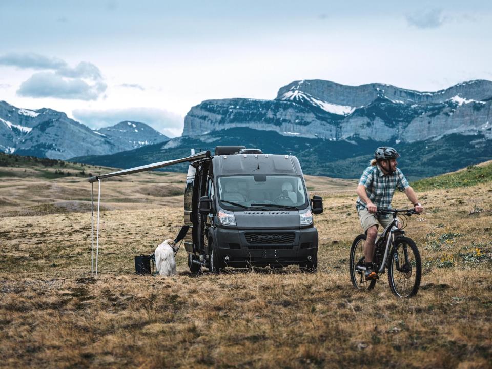 The exterior of Airstream's new Rangeline Touring Coach next to a biker