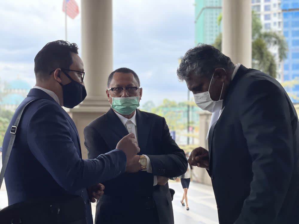 Datuk Mohd Puad Zarkashi (centre) speaks to his lawyers at the Kuala Lumpur High Court March 12, 2021. — Picture by Emmanuel Santa Maria Chin