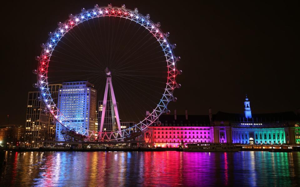 The London Eye and buildings along the South Bank are lit up with the colours of the Union flag during a nationwide clap in honour of Sir Tom  - Jonathan Brady/PA
