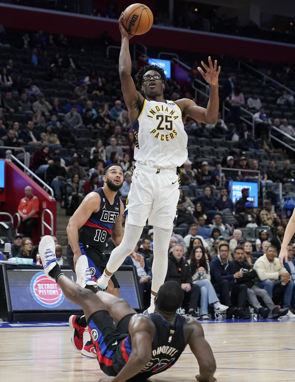 Indiana Pacers forward Jalen Smith (25) makes a layup over Detroit Pistons forward Eugene Omoruyi (97) during the second half of an NBA basketball game, Monday, March 13, 2023, in Detroit. (AP Photo/Carlos Osorio)