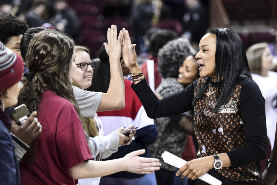 South Carolina coach Dawn Staley high fives fans after an NCAA college basketball game against Kentucky Thursday, Jan. 2, 2020, in Columbia, S.C. South Carolina defeated Kentucky 99-72.(AP Photo/Sean Rayford)