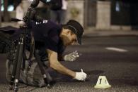 An Israeli police forensic officer collects evidence at the site where an ultra-orthodox Jew stabbed six people taking part in a Gay Pride march in central Jerusalem on July 30, 2015