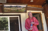 In this July 6, 2019, photo, Jeff Morehead stands near a panorama photo he took in 1994 of the Fish Creek Mobile Home Park and construction next door of the new Yampa River Botanic Park in Steamboat Springs, Colo. Some Colorado towns are taking action to preserve their remaining mobile home parks. Cities, counties and housing authorities, such as the Yampa Valley Housing Authority in Steamboat Springs, are buying mobile home parks to preserve affordable housing for residents as other mom-and-pop park owners sell out to developers or investors. (Matt Stensland/The Colorado Sun via AP)