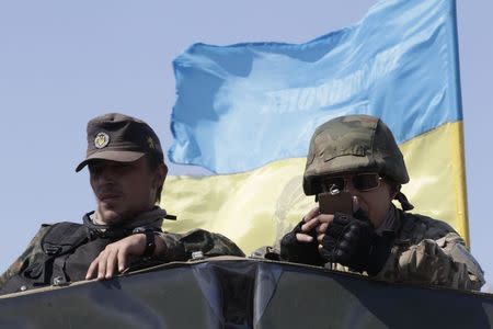 Soldiers of Ukrainian self-defence battalion "Azov" sit atop an armoured personnel carrier (APC) at a checkpoint in the southern coastal town of Mariupol, September 5, 2014. REUTERS/Vasily Fedosenko