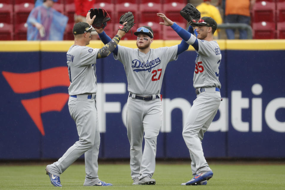 Los Angeles Dodgers center fielder Alex Verdugo (27) celebrates with first baseman Cody Bellinger (35) and left fielder Joc Pederson, left, after closing the ninth inning of a baseball game against the Cincinnati Reds, Sunday, May 19, 2019, in Cincinnati. (AP Photo/John Minchillo)