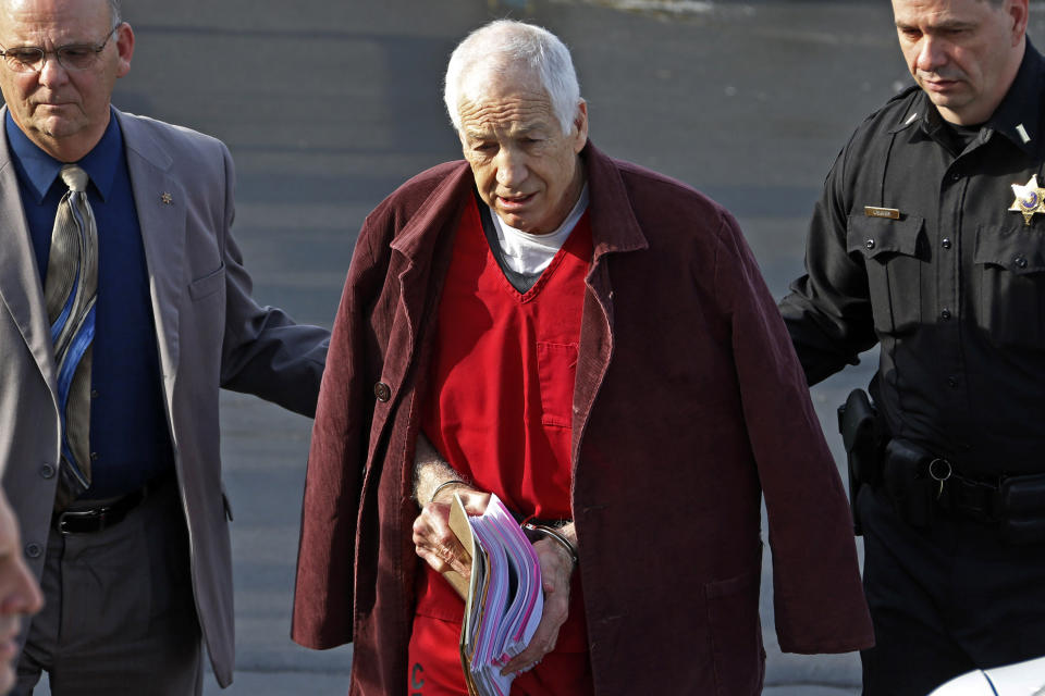 FILE - In this Jan. 10, 2013 file photo, former Penn State University assistant football coach Jerry Sandusky, center, leaves the Centre County Courthouse after attending a post-sentence motion hearing in Bellefonte, Pa. Sandusky is expected to participate in the proceeding to have his Penn State pension restored by video conference. The proceeding begins on Tuesday, Jan. 7, 2014. Sandusky lost a $4,900-a-month pension in October 2012, when he was sentenced to 30 to 60 years in prison for child sexual abuse. (AP Photo/Gene J. Puskar, File)