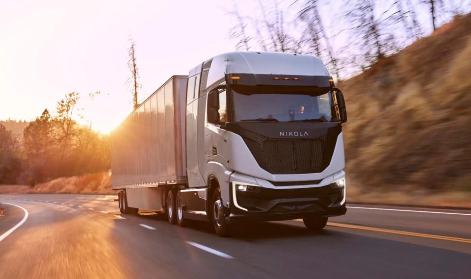 A Nikola Tre, an electric semi-truck powered by a hydrogen fuel cell, towing a trailer up a hill. 