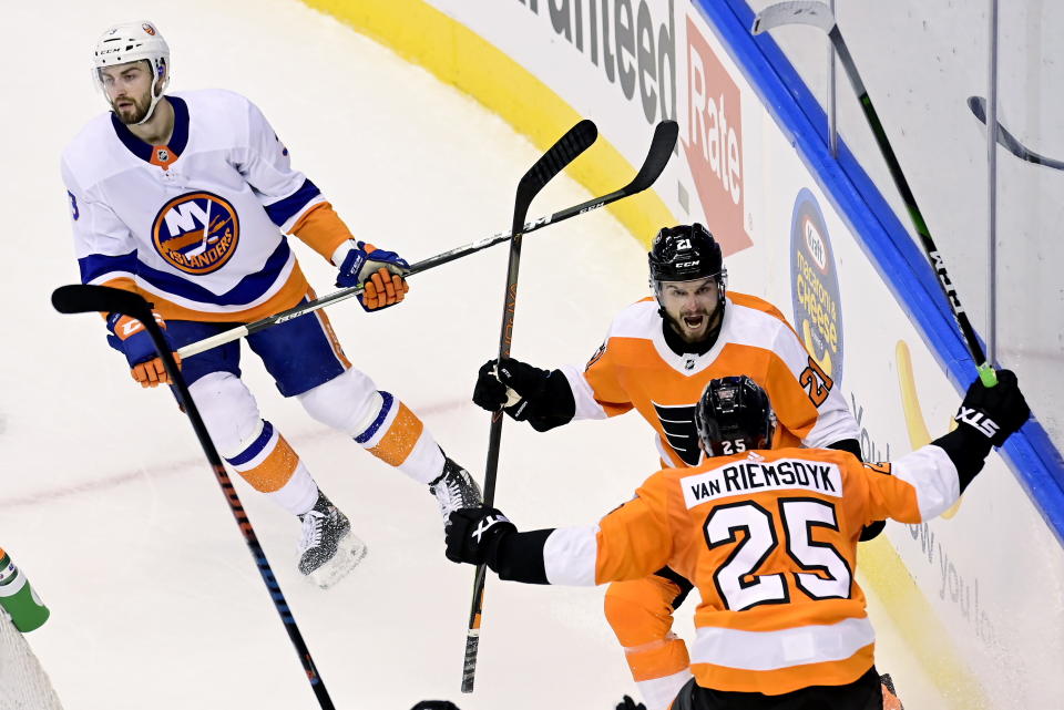 Philadelphia Flyers left wing James van Riemsdyk (25) celebrates his goal with teammate Scott Laughton (21) as New York Islanders defenseman Adam Pelech (3) skates past during the second period of an NHL Stanley Cup Eastern Conference playoff hockey game in Toronto, Ontario, Tuesday, Sept. 1, 2020. (Frank Gunn/The Canadian Press via AP)