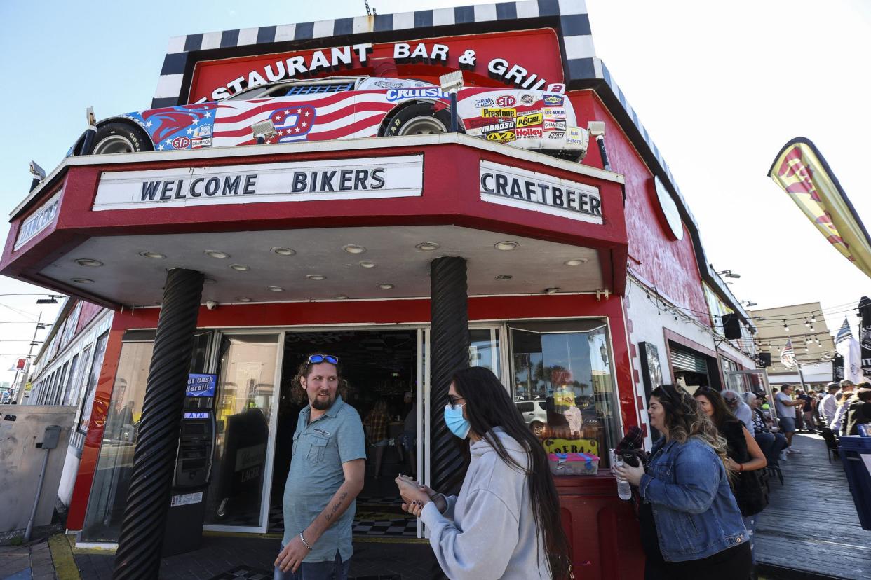 People walk by Cruisin Cafe on Main Street in Daytona, FL during the starting day of Bike Week on Friday, March 5, 2021. (Sam Thomas/Orlando Sentinel)