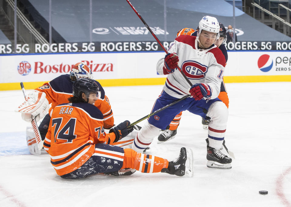 Edmonton Oilers' Ethan Bear (74) defends against Montreal Canadiens' Nick Suzuki (14) during first-period NHL hockey game action in Edmonton, Alberta, Saturday, Jan. 16, 2021. (Jason Franson/The Canadian Press via AP)