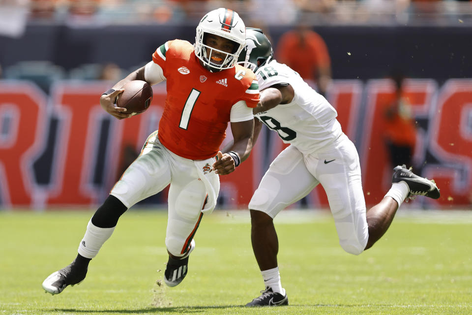 Miami quarterback D'Eriq King (1) breaks a tackle from Michigan State cornerback Kalon Gervin (18) during the second quarter of an NCAA college football game, Saturday, Sept. 18, 2021, in Miami Gardens, Fla. (AP Photo/Michael Reaves)