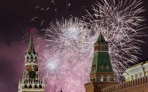 Fireworks light the night sky over the Kremlin and the Red square to mark the New Year in Moscow - Credit: Rex